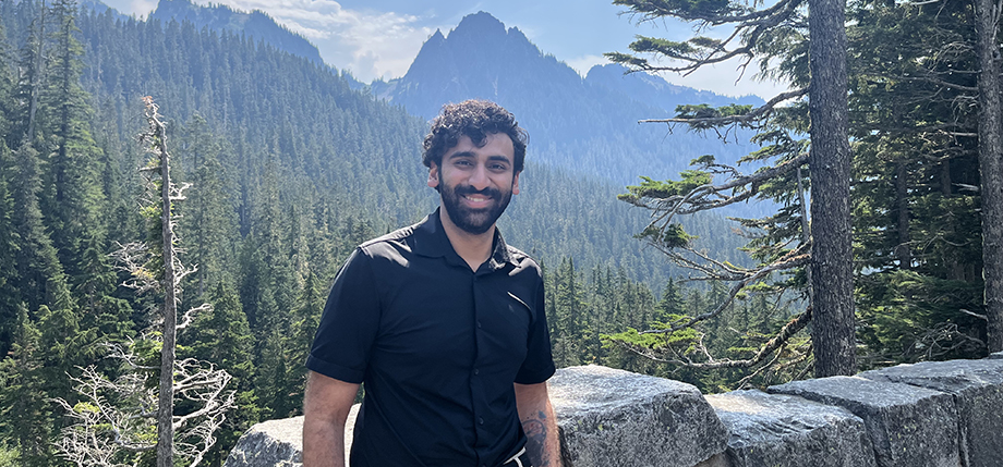 Raj Hoshing stands in front of a mountain backdrop.